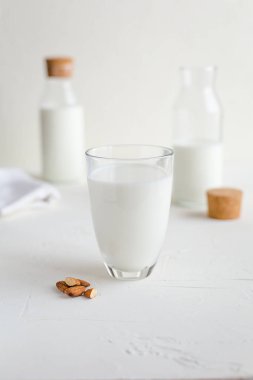 Şişe ve bardak taze süt. Badem veya inek süt. Beyaz arka plan.