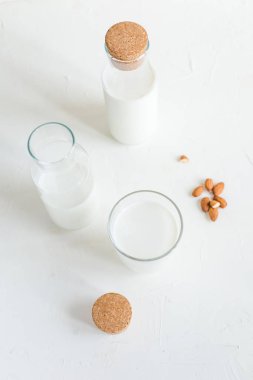 Şişe ve bardak taze süt. Badem veya inek süt. Beyaz arka plan.