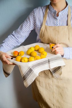 Bir adam bir tepsi ile kayısı ve nektarin tutar