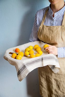 Bir adam bir tepsi ile kayısı ve nektarin tutar