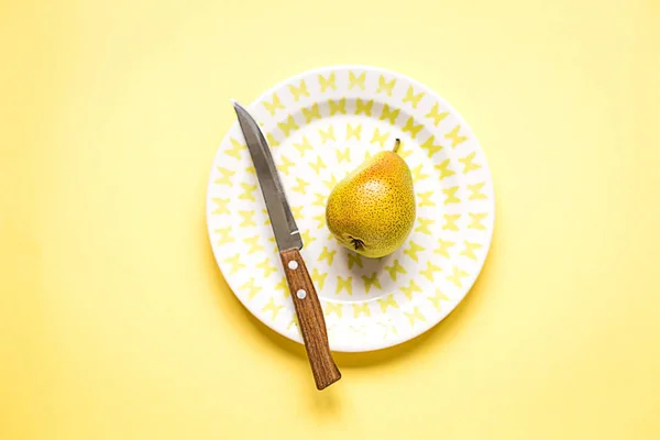 Colocação Plana Uma Pêra Madura Placa Fundo Papel Amarelo Conceito — Fotografia de Stock