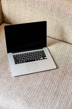 Kanepede dizüstü bilgisayar ve bazı şeyler vardır. Evde çalışan. Serbest kavramı