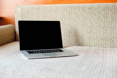 Kanepede dizüstü bilgisayar ve bazı şeyler vardır. Evde çalışan. Serbest kavramı