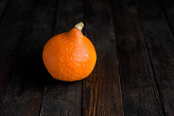 Orange pumpkins on dark wooden background