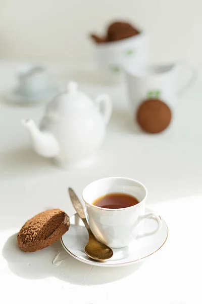 Breakfast on white table, tea and biscuits