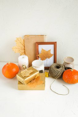 Beyaz arka plan üzerinde natürmort. Kitaplar Vintage, ahşap çerçeve, akçaağaç yaprakları, kırmızı pumpkins, mumlar ve dekorasyon kuru. Sonbahar konsepti