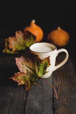 Bir fincan ev yapımı Sütlü Balkabağı. Koyu ahşap arka plan, kırmızı balkabağı. Sonbahar gıda kavramı, tonlu görüntü