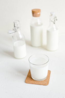 Şişe ve cam beyaz beton zemin üzerine taze süt. Sağlıklı gıda, mutfak.
