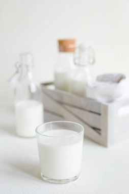 Şişe ve cam beyaz beton zemin üzerine taze süt. Sağlıklı gıda, mutfak.