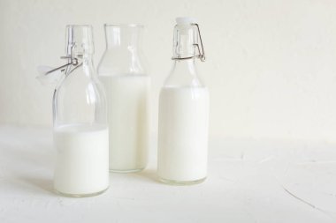 Şişe ve cam beyaz beton zemin üzerine taze süt. Sağlıklı gıda, mutfak.