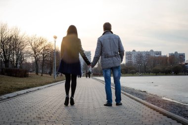 Sevgili genç insanlar açık yürüyor. Şehirde sonbahar su birikintisi. Kentsel tarzı.