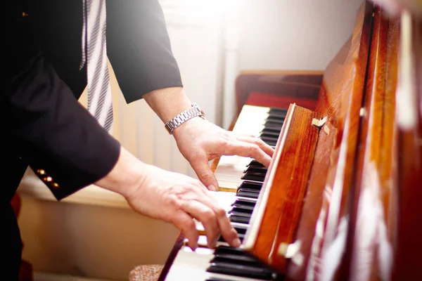 A piano player or a teacher of music. Hans of a musician on piano keys.