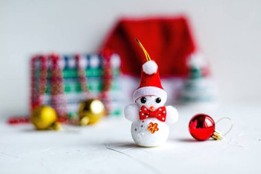 Beyaz arka plan üzerinde Noel kardan adam, oyuncak ve kırmızı şapka. Tatil kavramı.