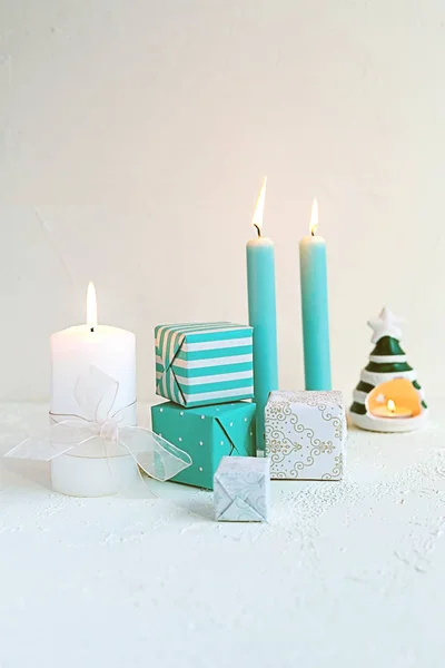 Shabby chic candles and gift boxes on white. Christmas composition.