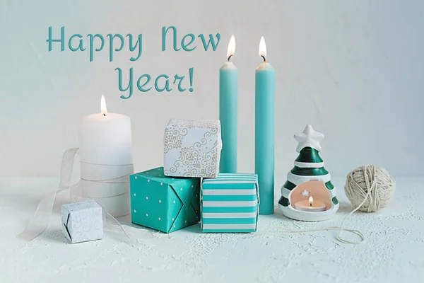 Shabby chic candles and gift boxes on white. Christmas composition. Happy new year text.