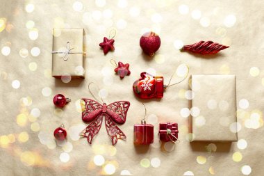 Düz kırmızı ve sarı Noel oyuncaklar altın Kağıt arka plan üzerinde yatıyordu. Tatil kavramı, üstten görünüm.