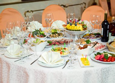 Tablo birden fazla kişiye güzel bir restoranda görev yaptı. Akşam yemeği ya da parti zamanı.