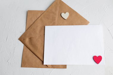 Üstten görünüm bir sevgili kişiye bir mektup. Kraft Kağıt zarf, ahşap küçük kalp, vardiyasında beyaz masa kağıt.