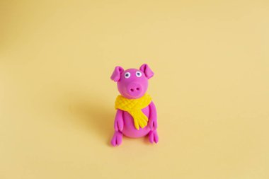 Küçük el Sarı eşarp domuzla mor hamuru yapımı renkli kağıt arka plan üzerinde olduğunu. Çin yeni yılı ve Çin tatil kavramı sembolü.