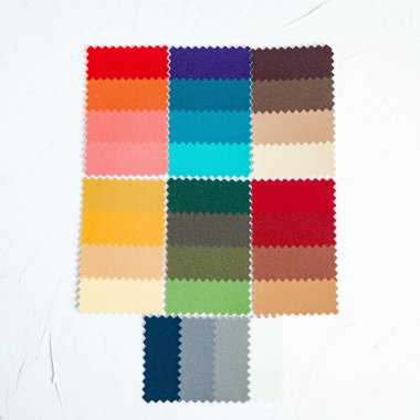 Beyaz beton masada üstten görünüm renkli keçe örnekleri. İmaj maker renk türü tayini için stilist enstrümanın.