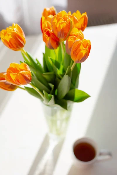 Tulipas laranja primavera em um vaso perto da janela — Fotografia de Stock