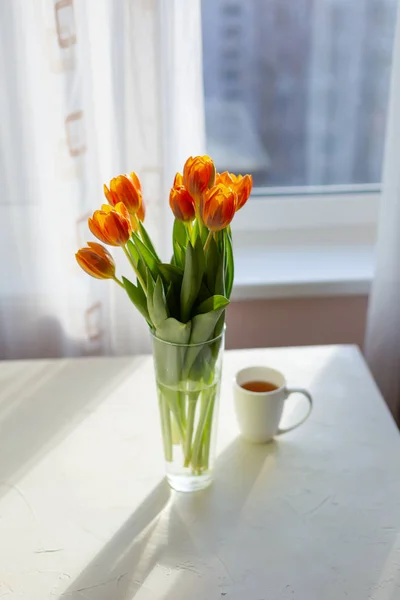Tulipas laranja primavera em um vaso perto da janela — Fotografia de Stock