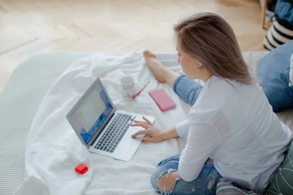 Blonde fiatal nő laptop van ágyon — Stock Fotó