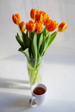 Pencerenin yakınında bir vazo bahar turuncu lale