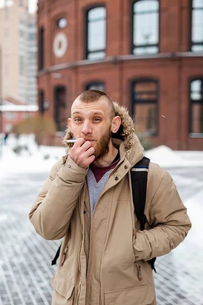 겨울에 담배를 피우는 수염을 기한 청년 — 스톡 사진