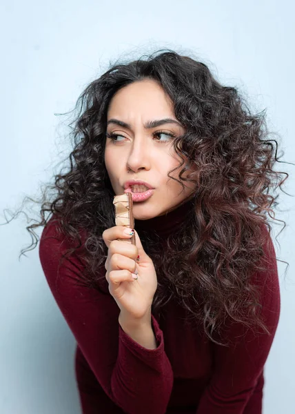 Menina come um chocolate e mostra emoções — Fotografia de Stock