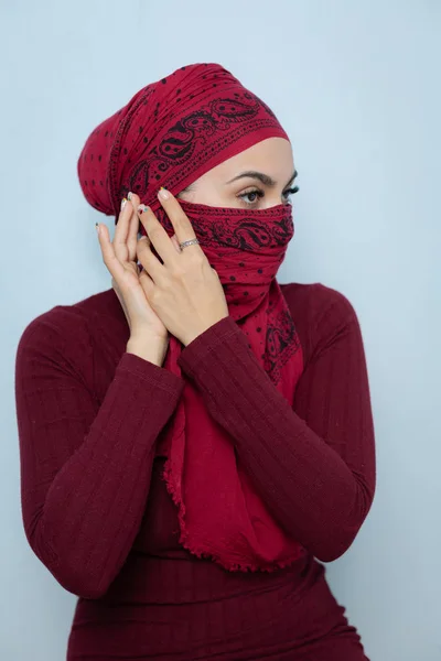 Μια νεαρή μουσουλμανική γυναίκα δένει το κόκκινο μαντήλι — Φωτογραφία Αρχείου