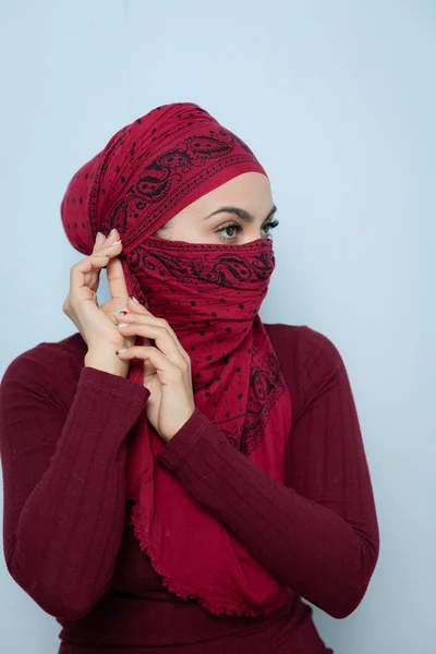 Μια νεαρή μουσουλμανική γυναίκα δένει το κόκκινο μαντήλι — Φωτογραφία Αρχείου