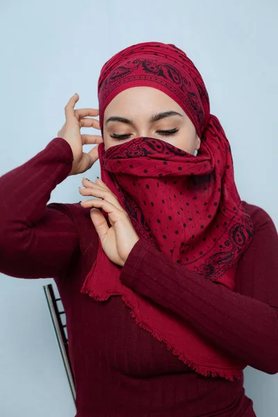 A young muslim woman ties the red handkerchief