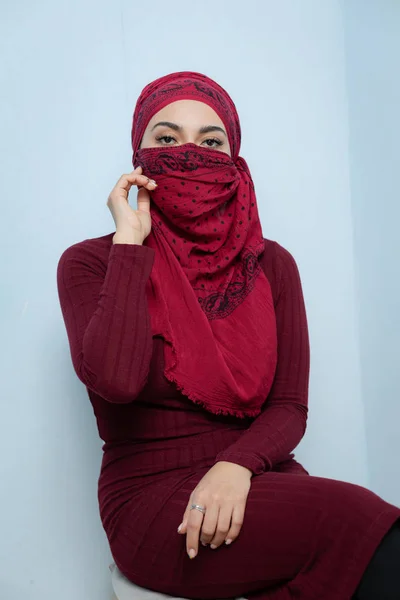 Uma jovem mulher muçulmana amarra o lenço vermelho Imagens Royalty-Free