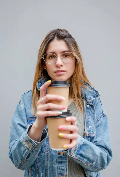 Szőke lány papír csésze kávét szürke — Stock Fotó