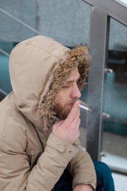 Sakallı, Genç bir adam kışın sigara içiyor.