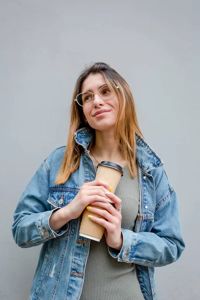 Menina loira com xícaras de papel de café em cinza — Fotografia de Stock