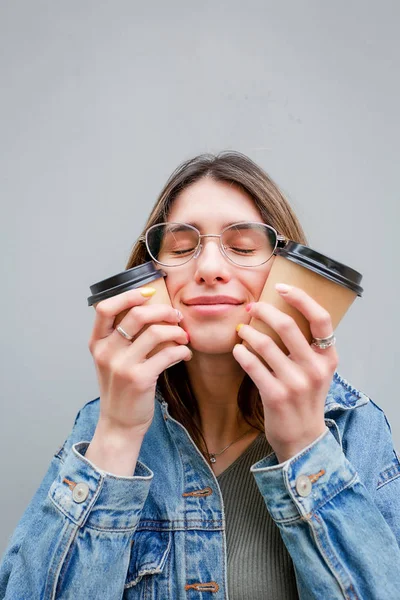 Menina loira com xícaras de papel de café em cinza — Fotografia de Stock