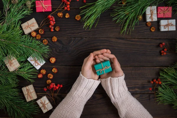 Manos Niña Sosteniendo Regalo Navidad Fondo Las Ramas Pino Pizarras — Foto de Stock