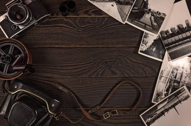 Eski kamera, acsessories ve siyah-beyaz fotoğraflar koyu ahşap yüzeyde tarafından. Retro. Üstten görünüm
