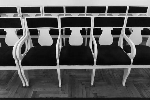 Rows of old chairs in the auditorium. Black and white photo