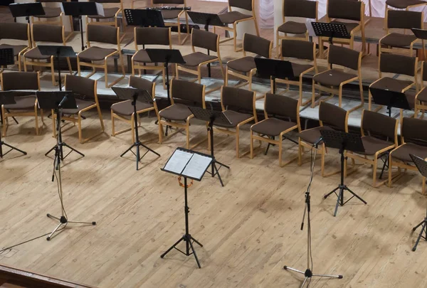 Empty stage with chairs, microphones and music stands before the concert. Arranged in a semicircle. Top view