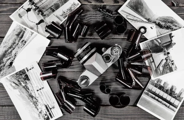 Eski kamera, film ve siyah-beyaz fotoğraflar koyu ahşap yüzeyde tarafından. Retro. Üstten görünüm