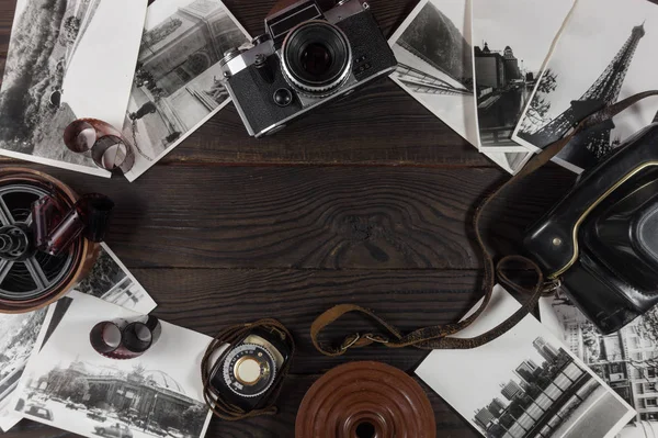 旧相机 Acsessories 和黑白照片都在深色的木质表面上 顶部视图 — 图库照片