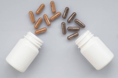 Tıbbi kapsül dökmek dışarı ışık bir yüzeye iki plastik şişe