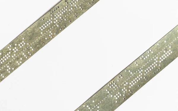 Strips of old punched tape on white surface