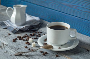 Kahve fincanı, beens ve sürahi bir arka plan mavi kurullarının