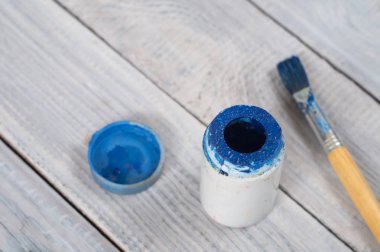 Mavi boya ve fırça beyaz tahtalar arka plan üzerinde