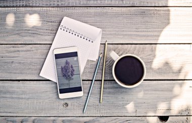 Kahve, Not defteri, telefon fincan fotoğraf Beyaz ahşap masa leylak dalı ile