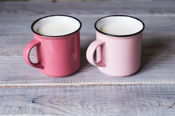 Deux Tasses Roses Avec Lait Sur Table Bois Blanc — Photo